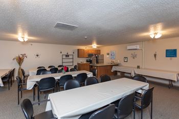 Community room with full kitchen and large banquet tables with white tableclothes